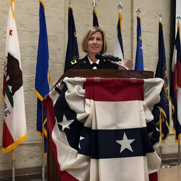 Michelle Letcher stands at a podium at a military speaking event.