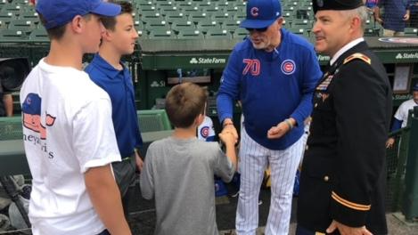 Chicago Cubs shake fans' hands at a game.